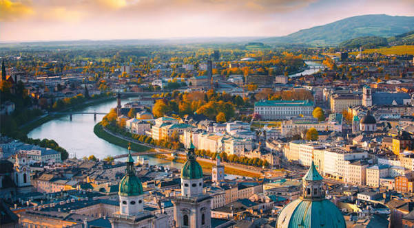 Historic European city beside a river at sunset
